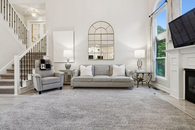 9455 Foothills Ct, Brentwood, TN 37027 - living area featuring stairs, a high ceiling, a fireplace with flush hearth, and wood finished floors