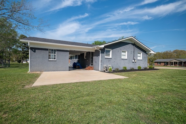 703 Brenda Ave, Loretto, TN 38469 - back of house featuring brick siding, a yard, an attached carport, a patio area, and entry steps