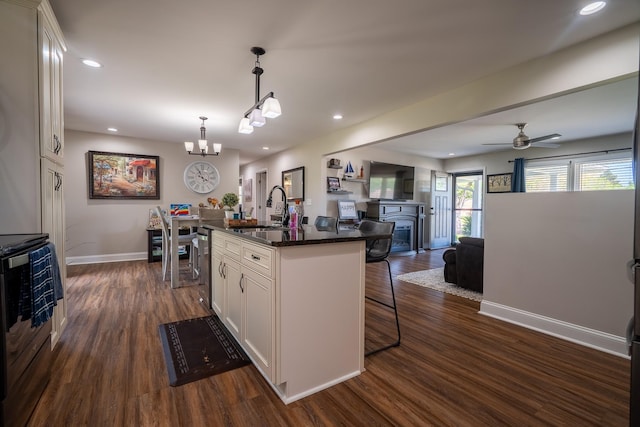 703 Brenda Ave, Loretto, TN 38469 - kitchen featuring a sink, baseboards, a kitchen breakfast bar, open floor plan, and white cabinets