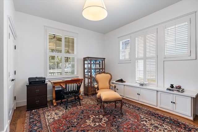 living area featuring an office area, wood finished floors, and baseboards