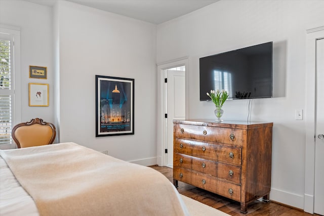 bedroom with baseboards and wood finished floors