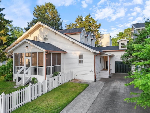 view of front of property featuring a sunroom, concrete driveway, a garage, and a shingled roof