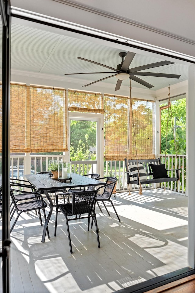 sunroom with a ceiling fan and outdoor dining space
