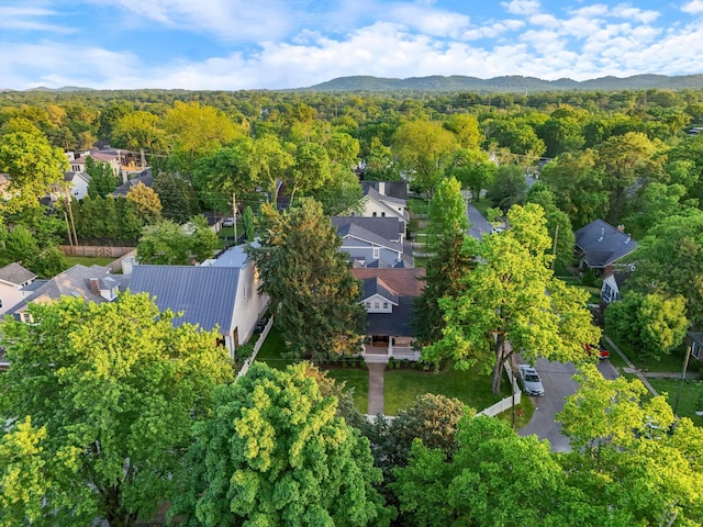 aerial overview of property's location featuring a heavily wooded area and a mountainous background