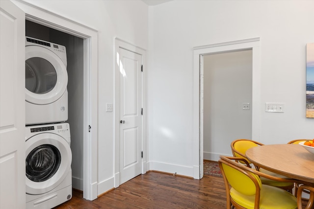 laundry room with stacked washer and clothes dryer, dark wood-style flooring, and baseboards