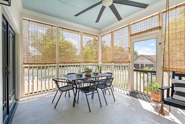 sunroom / solarium with ceiling fan and outdoor dining space