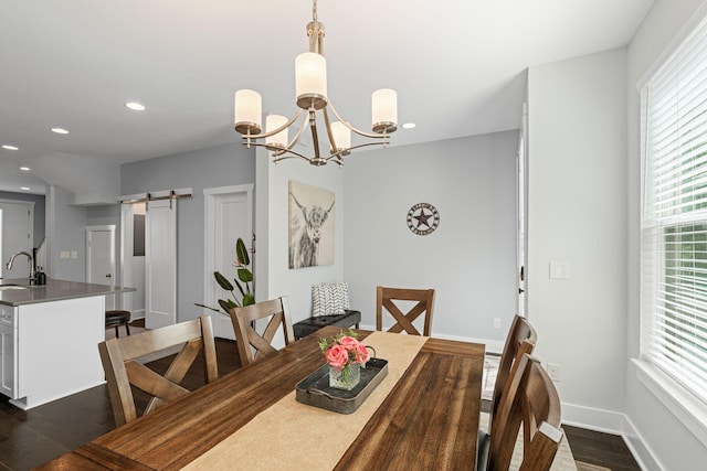 dining area with a barn door, dark wood-style floors, a chandelier, baseboards, and recessed lighting