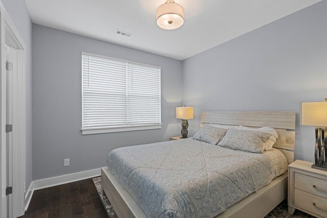 bedroom featuring dark wood-style floors and baseboards