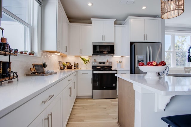 5211 Gladecress Ln, Hermitage, TN 37076 - kitchen featuring appliances with stainless steel finishes, recessed lighting, a kitchen breakfast bar, light countertops, and white cabinets