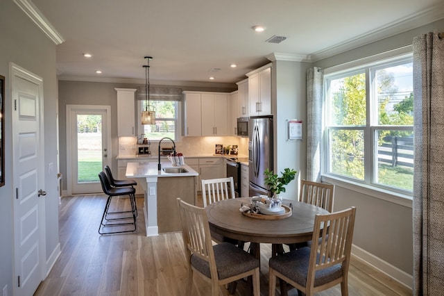 5211 Gladecress Ln, Hermitage, TN 37076 - dining area featuring light wood finished floors, crown molding, baseboards, and recessed lighting