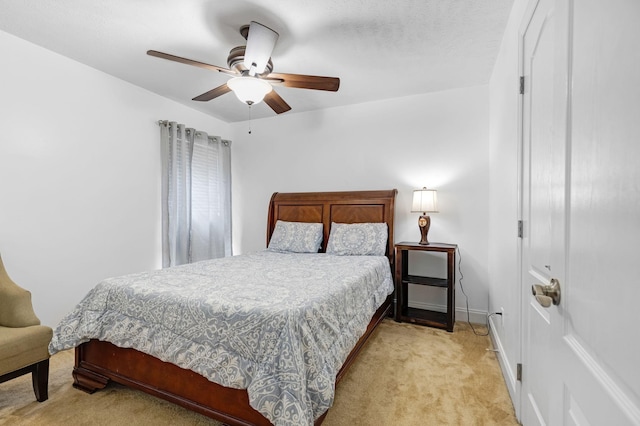 bedroom featuring light colored carpet, baseboards, and a ceiling fan