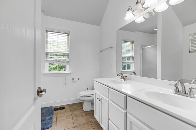 bathroom with a shower stall, plenty of natural light, double vanity, and toilet