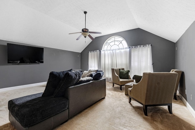 living area featuring lofted ceiling, light colored carpet, ceiling fan, a textured ceiling, and baseboards