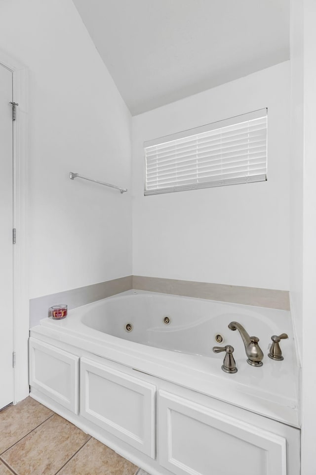 full bathroom featuring a jetted tub, tile patterned floors, and lofted ceiling