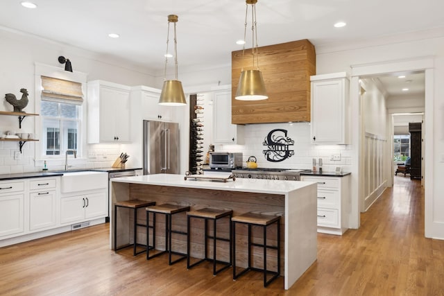 1224 Adams St, Franklin, TN 37064 - kitchen featuring appliances with stainless steel finishes, a sink, backsplash, a kitchen bar, and crown molding