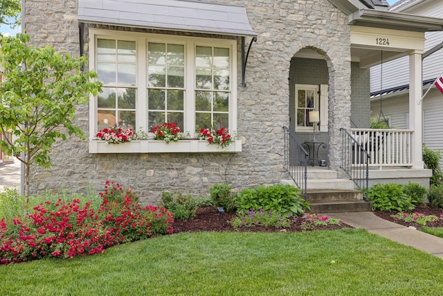 1224 Adams St, Franklin, TN 37064 - view of exterior entry with stone siding, a lawn, and a porch