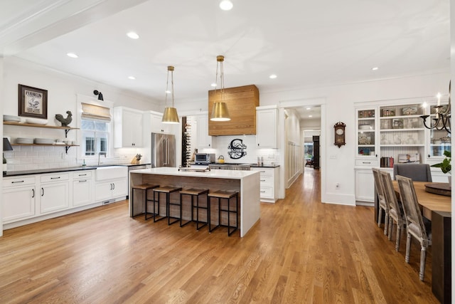 1224 Adams St, Franklin, TN 37064 - kitchen featuring high quality fridge, a kitchen breakfast bar, decorative backsplash, open shelves, and white cabinets