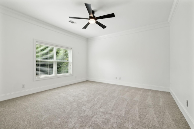 empty room with crown molding, carpet flooring, ceiling fan, and baseboards