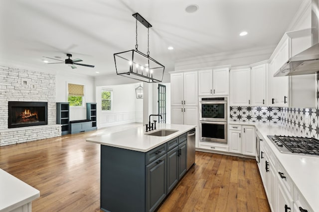 kitchen with a sink, appliances with stainless steel finishes, gray cabinets, white cabinets, and recessed lighting