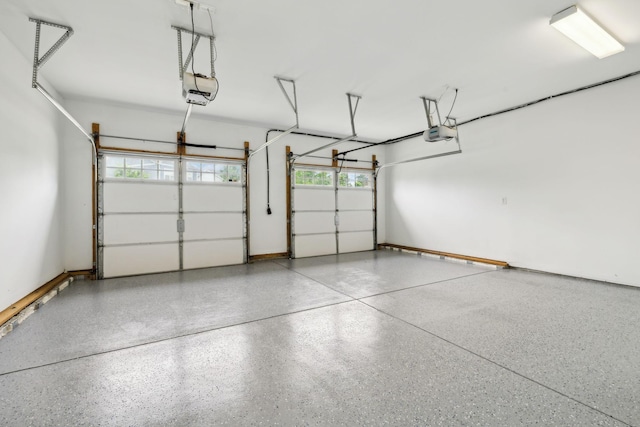 garage featuring a garage door opener and baseboards