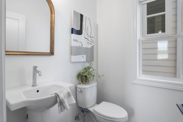 half bathroom with toilet and a sink