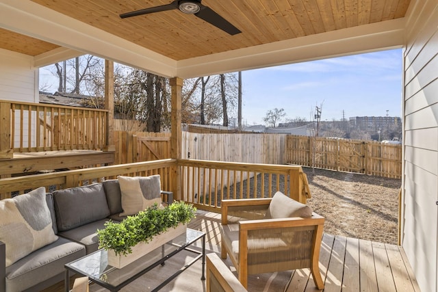 wooden deck with an outdoor hangout area, ceiling fan, and a fenced backyard