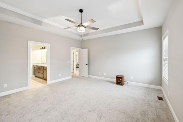 2219 Ovoca Rd, Tullahoma, TN 37388 - unfurnished bedroom featuring a tray ceiling, light colored carpet, baseboards, ornamental molding, and connected bathroom