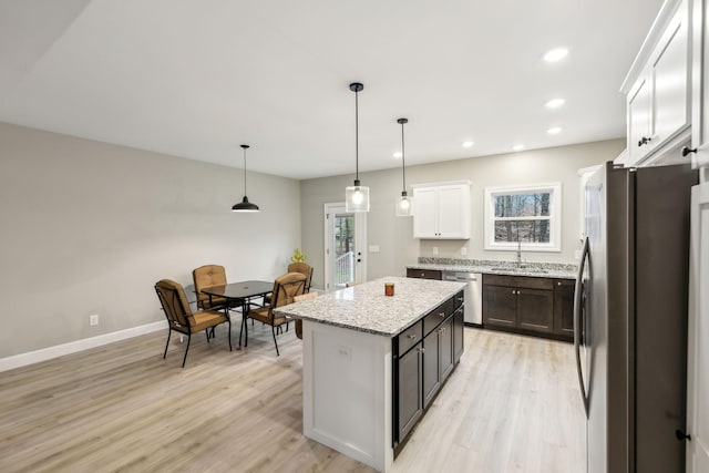 2219 Ovoca Rd, Tullahoma, TN 37388 - kitchen featuring appliances with stainless steel finishes, a sink, light wood-type flooring, light stone counters, and a center island