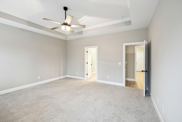 2219 Ovoca Rd, Tullahoma, TN 37388 - unfurnished bedroom featuring a tray ceiling, light colored carpet, baseboards, ornamental molding, and ensuite bathroom