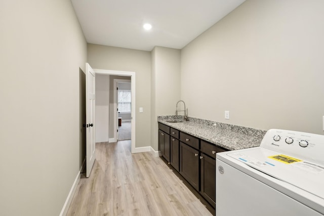 2219 Ovoca Rd, Tullahoma, TN 37388 - clothes washing area with washer / clothes dryer, cabinet space, light wood-style flooring, and baseboards