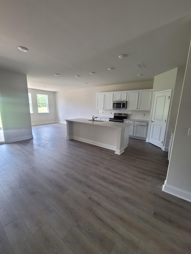 128 Holly Rdg, Antioch, TN 37013 - kitchen with appliances with stainless steel finishes, open floor plan, dark wood-style flooring, white cabinetry, and a kitchen island with sink