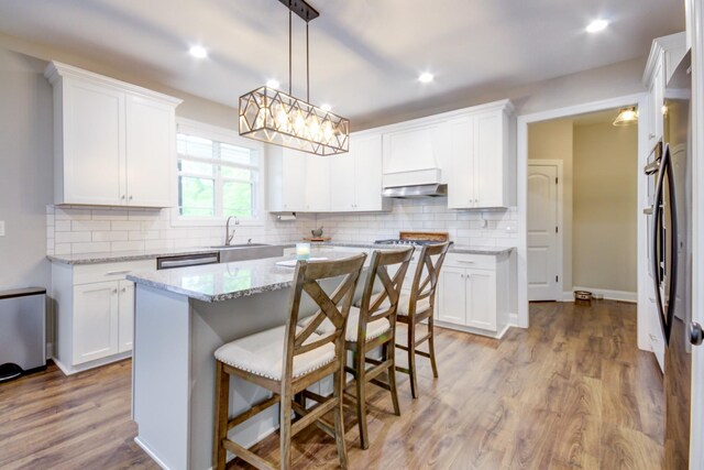 864 S Ridge Trl, Clarksville, TN 37043 - kitchen with white cabinetry, light wood finished floors, under cabinet range hood, a sink, and recessed lighting