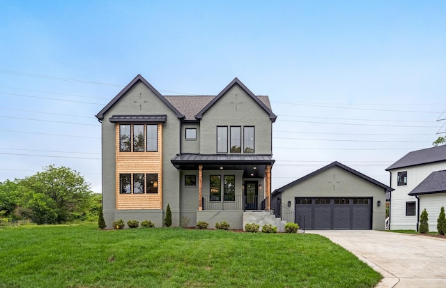 view of front of home with covered porch, a front lawn, a standing seam roof, a detached garage, and metal roof