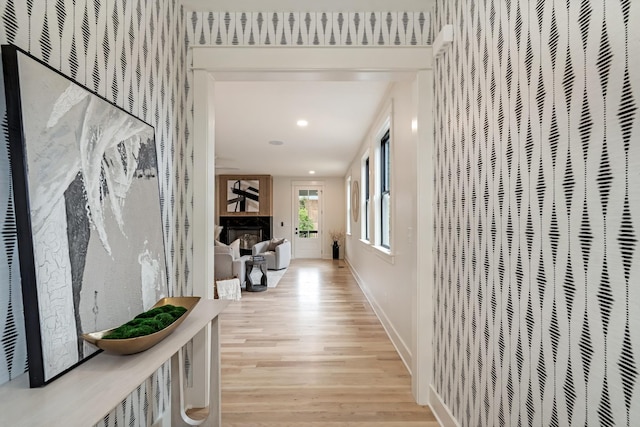 hall featuring light wood-style floors, recessed lighting, baseboards, and a heating unit