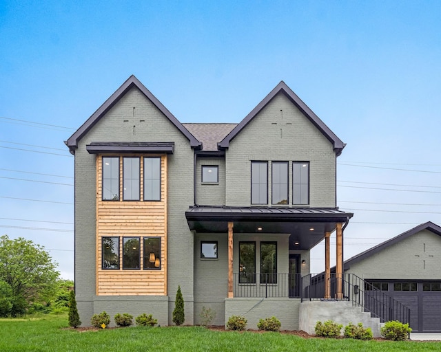 view of front of house featuring a porch, brick siding, a standing seam roof, a front lawn, and a garage