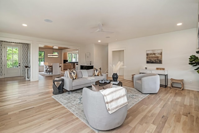 living room with light wood-style flooring, recessed lighting, baseboards, and a ceiling fan
