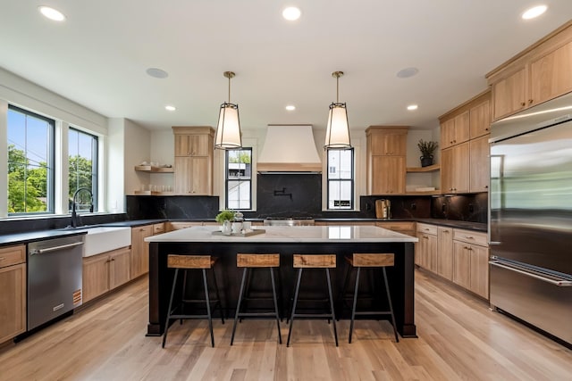 kitchen featuring open shelves, appliances with stainless steel finishes, custom range hood, a kitchen bar, and recessed lighting