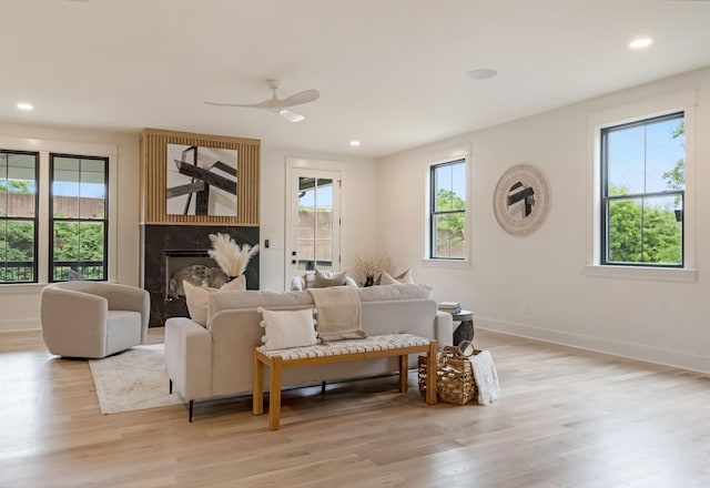 living room with light wood finished floors, baseboards, a fireplace, ceiling fan, and recessed lighting