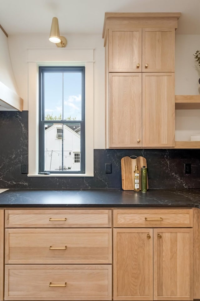 kitchen with light brown cabinetry, dark countertops, open shelves, and tasteful backsplash