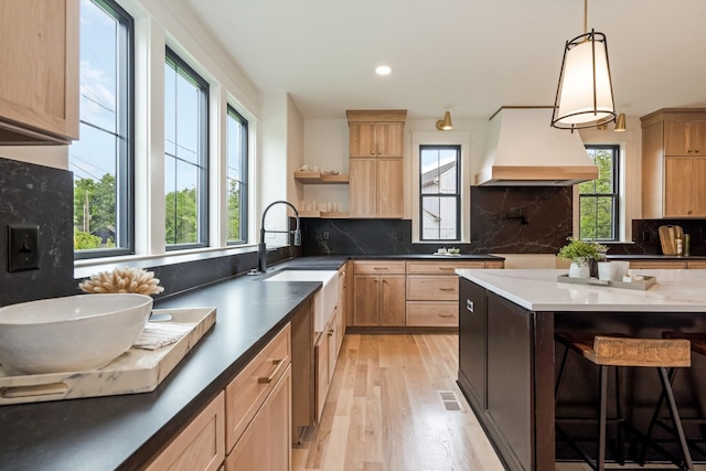 kitchen featuring premium range hood, healthy amount of natural light, light brown cabinetry, open shelves, and recessed lighting