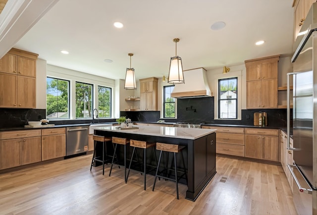 kitchen with open shelves, custom exhaust hood, appliances with stainless steel finishes, backsplash, and a kitchen bar
