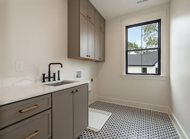 washroom featuring electric dryer hookup, washer hookup, cabinet space, and baseboards