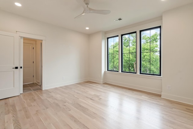 spare room featuring light wood-style floors, recessed lighting, ceiling fan, and baseboards