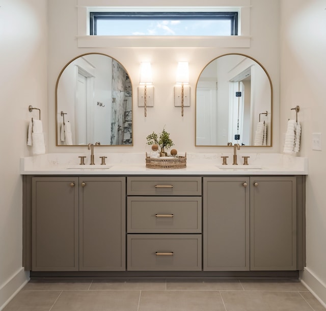 full bathroom with tile patterned floors, baseboards, double vanity, and healthy amount of natural light
