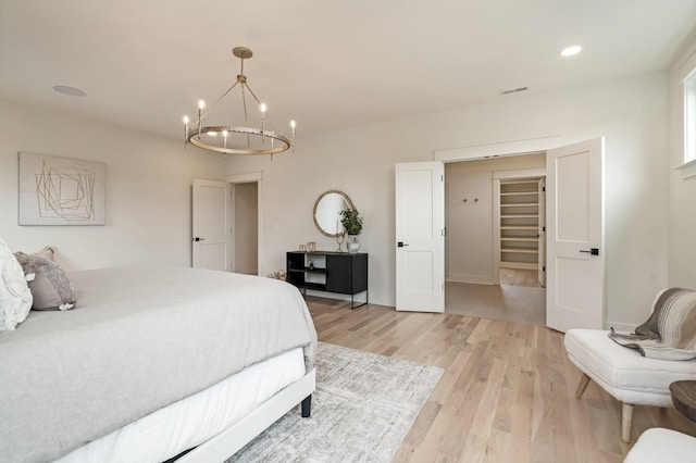 bedroom featuring a chandelier, light wood-type flooring, recessed lighting, and baseboards