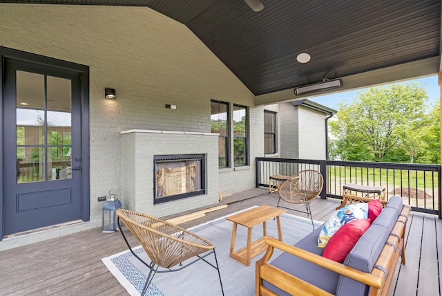 deck with an outdoor living space with a fireplace
