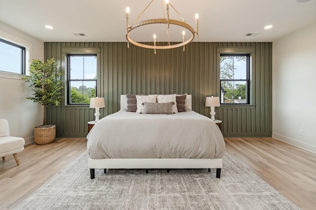 bedroom featuring light wood-style floors, baseboards, multiple windows, a chandelier, and recessed lighting