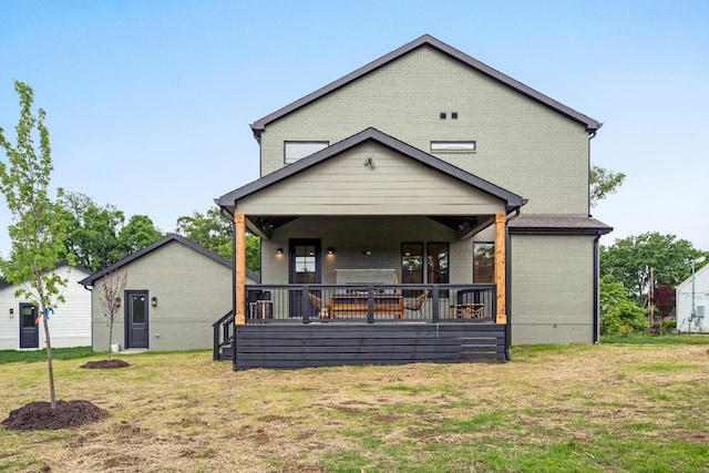 back of house with brick siding and a yard