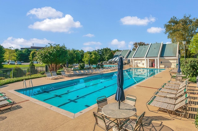 community pool with a patio area and fence