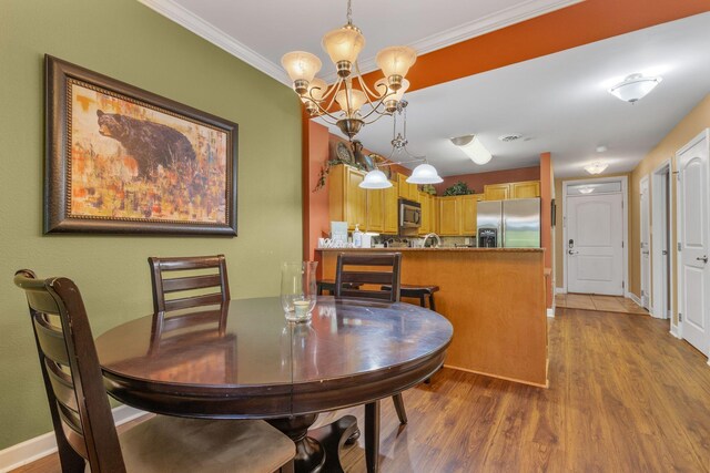1410 Hurley Dr Unit 103, Sevierville, TN 37862 - dining space featuring wood finished floors, a chandelier, ornamental molding, and baseboards